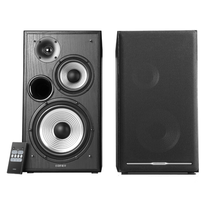 A pair of Edifier bookshelf speakers shown at an angle with a remote control below them; the left speaker has a mesh front grill while the right speaker shows the drivers without a front grill.