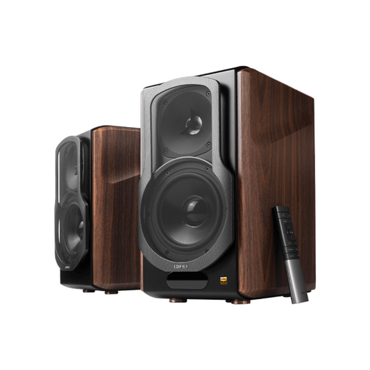A pair of wood brown Edifier S2000MKIII bookshelf speakers shown at an angle to see both the front and sides, with a black and grey remote control below them on a stand, highlighting the speakers' sleek design and incredible build quality.
